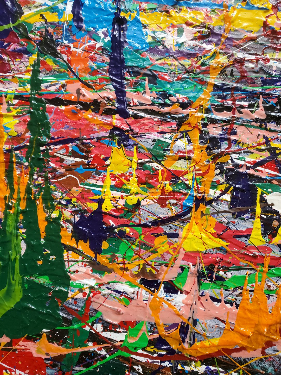 Thick, textured paint splatters in multiple bright colors.